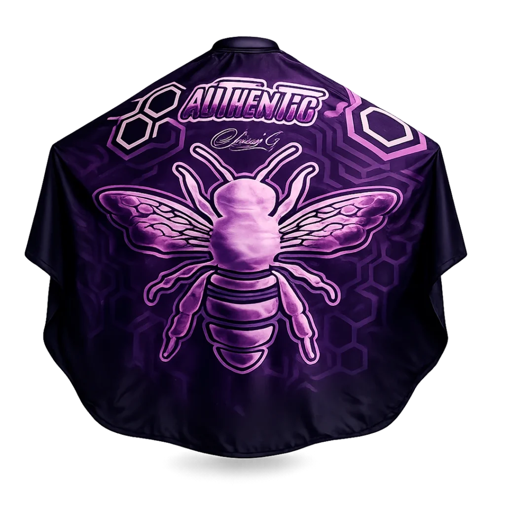 Capa de barbería profesional Authentic Muberry, tela antifluidos morada con diseño de abeja y patrones geométricos.
